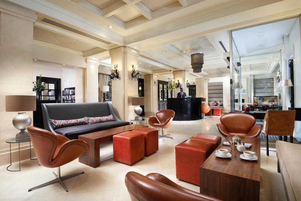 a living room with a couch and some chairs at London Bridge Hotel in London