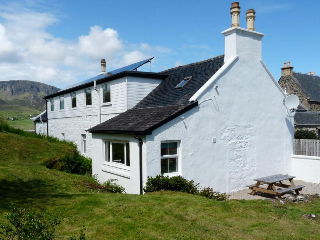 a white house with a picnic table in front of it at Holiday Home Keepers by Interhome in Staffin