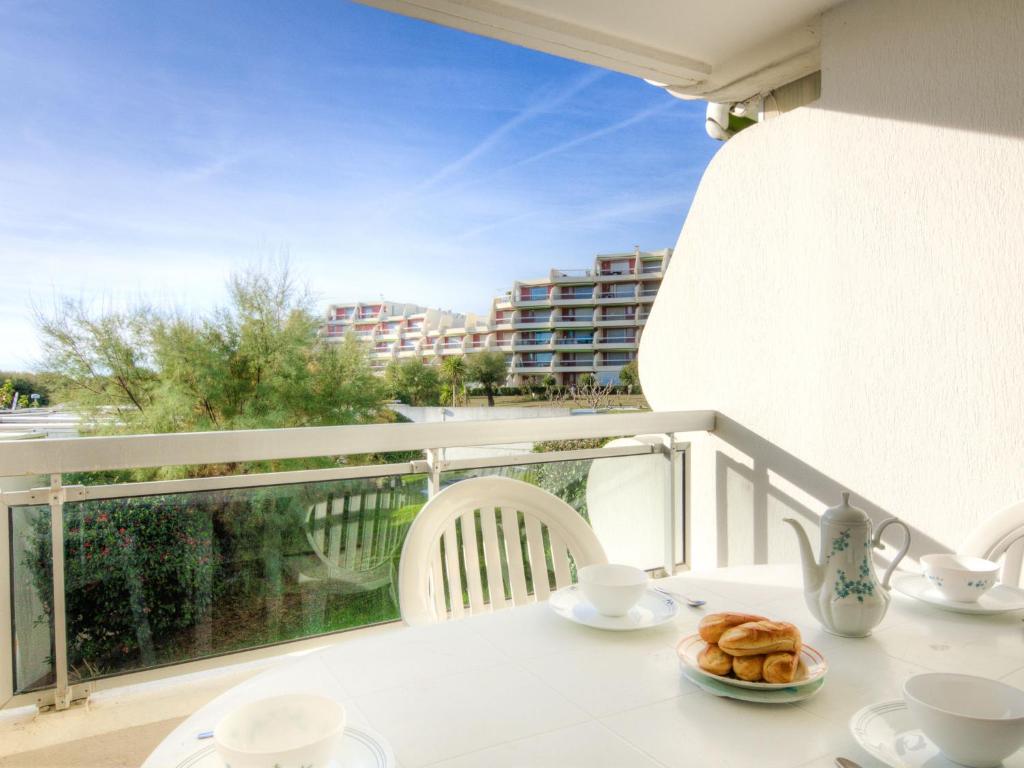 - une table avec un plateau de pâtisseries sur un balcon dans l'établissement Apartment Arena-4 by Interhome, à La Grande Motte