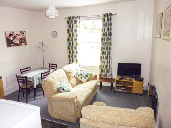 ein Wohnzimmer mit einem Sofa und einem Tisch in der Unterkunft Harley Apartment in Bishops Castle