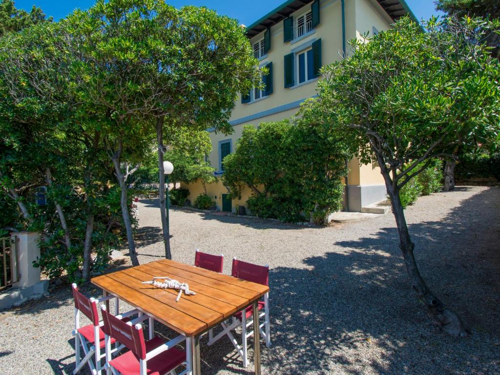 a wooden table and chairs in front of a building at Villa Tamerici by Interhome in Villa Boretti