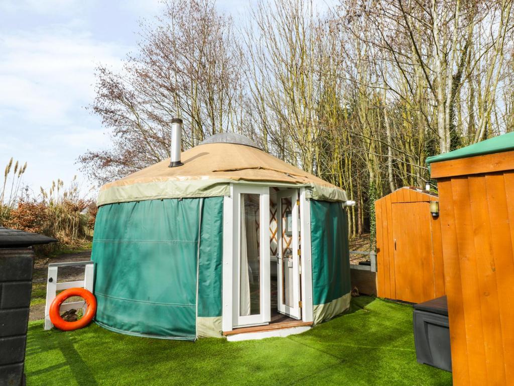una yurta sull'erba in un cortile di The Lakeside Yurt a Tewkesbury