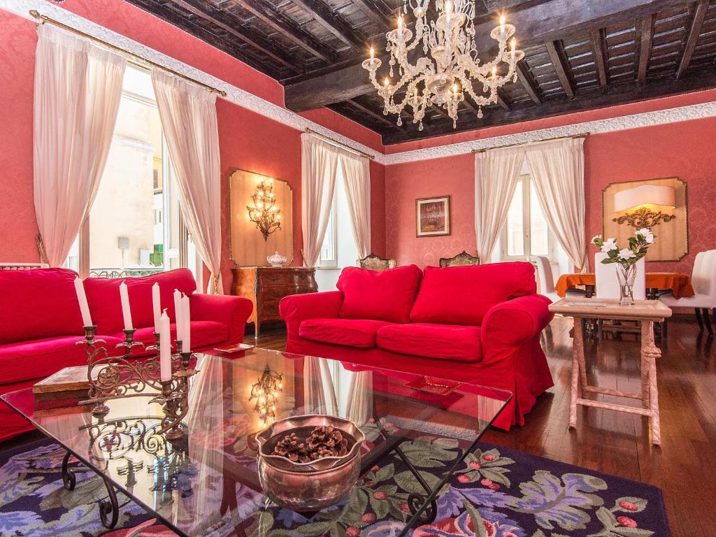 ローマにあるApartment Spanish Steps Top Location by Interhomeの赤い家具とシャンデリアが備わるリビングルーム