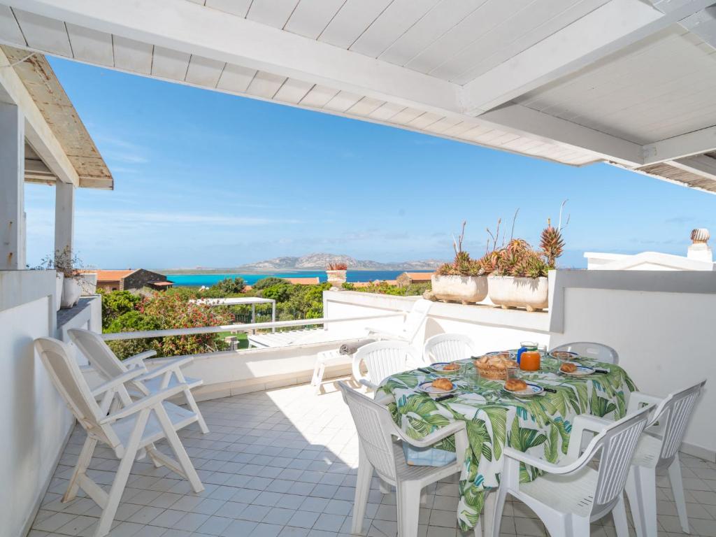 eine Terrasse mit einem Tisch und Stühlen auf dem Balkon in der Unterkunft Holiday Home Sa Casitta by Interhome in Stintino