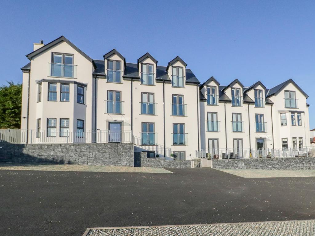 a large white building with a row of windows at Hafan Traeth Beach Haven in Benllech