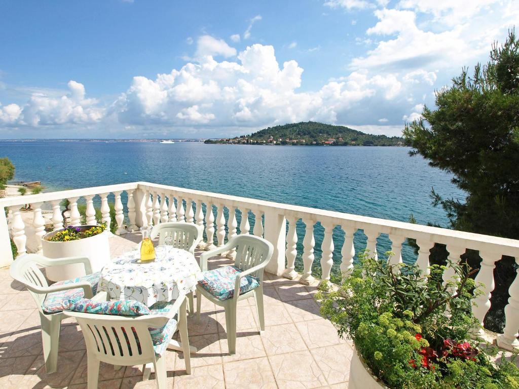 een tafel en stoelen op een balkon met uitzicht op het water bij Holiday Home Ana by Interhome in Kali