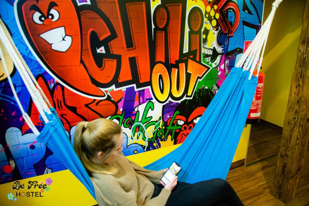 a woman sitting on a swing set with a wii controller at BeFree Hostel - Self-Service in Vienna
