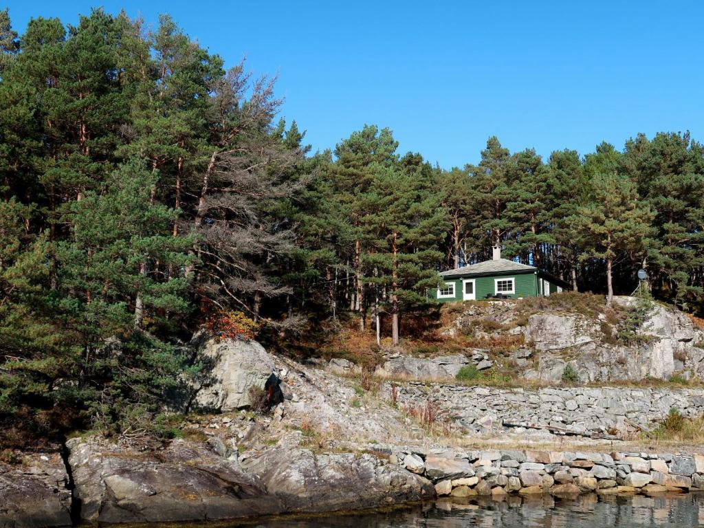 a house on top of a rocky hill next to the water at Holiday Home Blåsenberg - FJS126 by Interhome in Leirvik