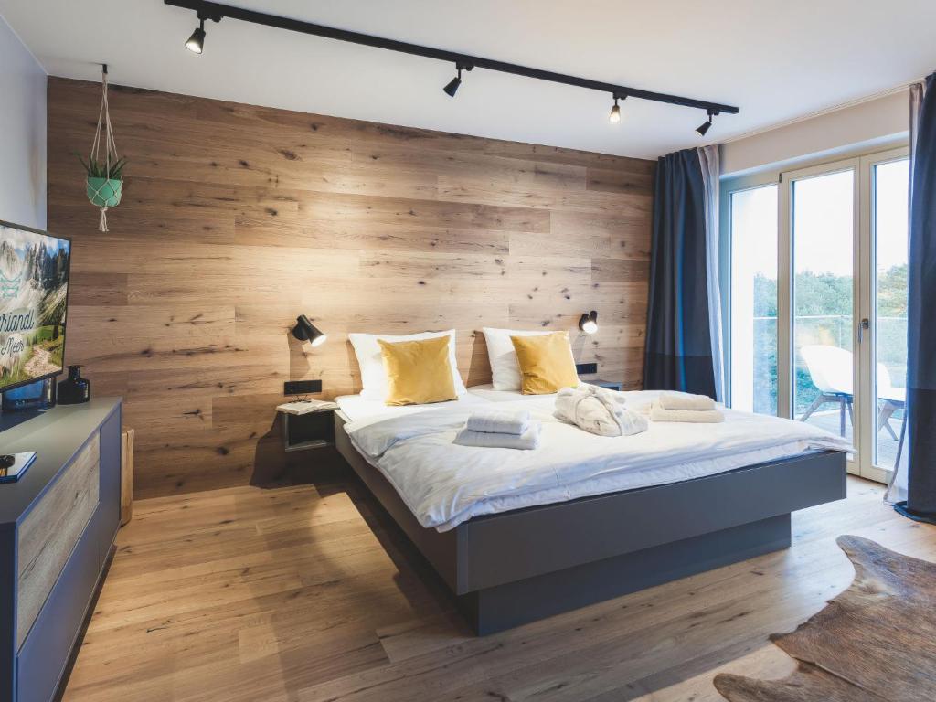 a bedroom with a large bed with a wooden wall at Apartment Mariandl am Meer-1 by Interhome in Binz