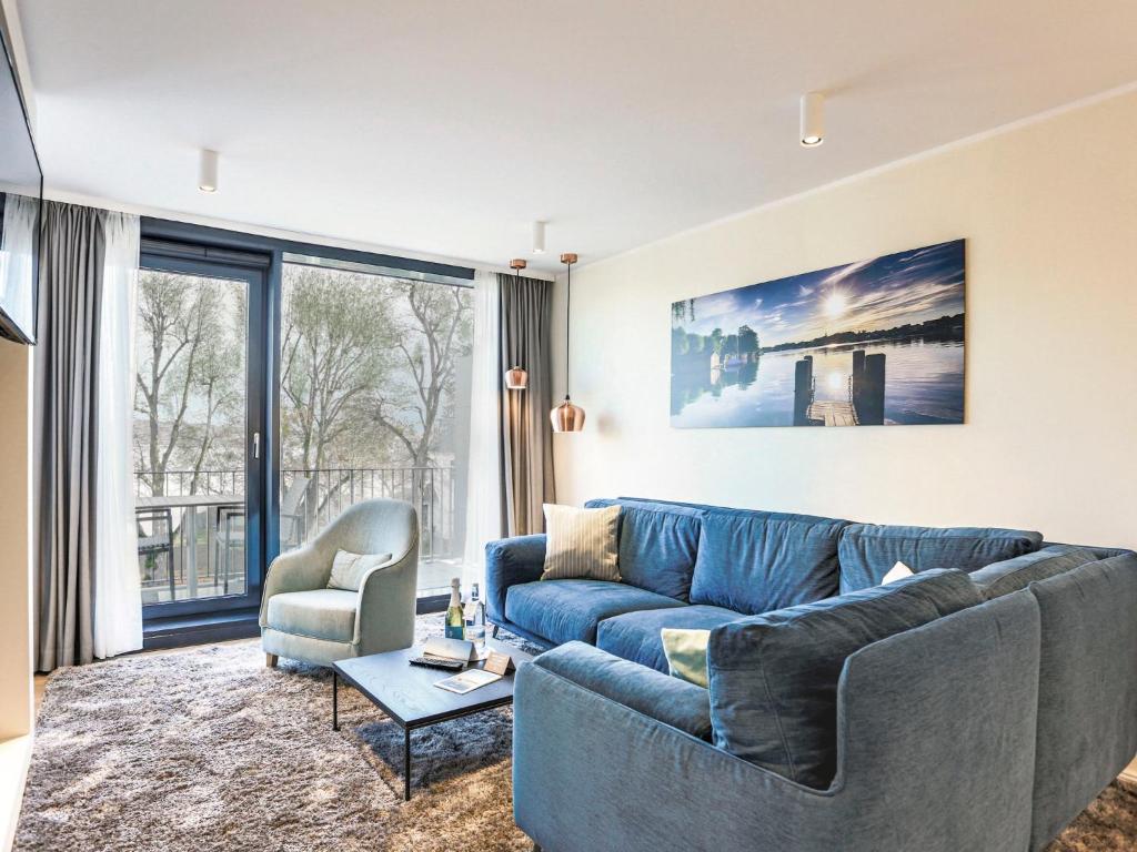 un soggiorno con divano blu e sedia di Apartment Maremüritz-Kompass by Interhome a Waren