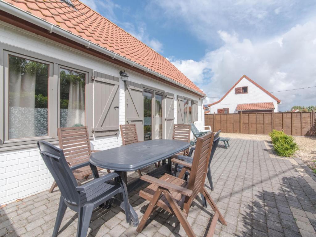 a table and chairs on the patio of a house at Holiday Home New Village Park-3 by Interhome in Bredene