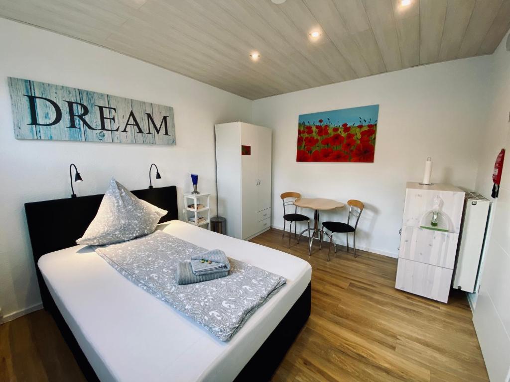 a bedroom with a bed and a table with chairs at Pensionszimmer Melina in Lübeck