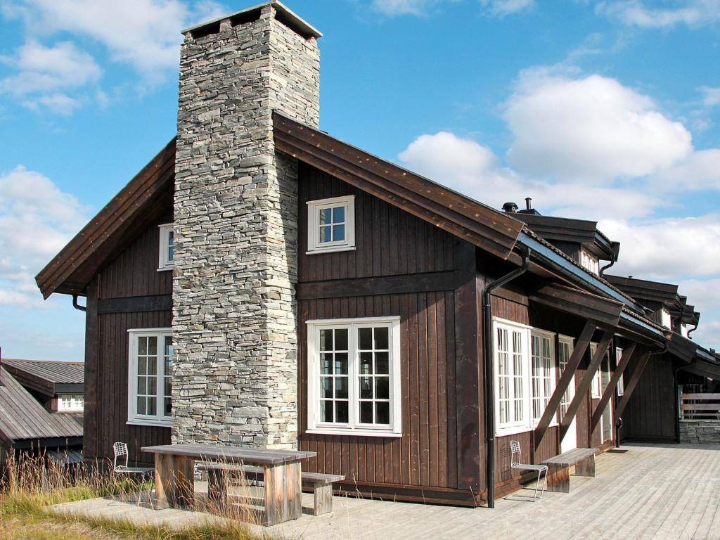 a log cabin with a chimney and a brick at Apartment Havsdalsgrenda - HLD103 by Interhome in Geilo