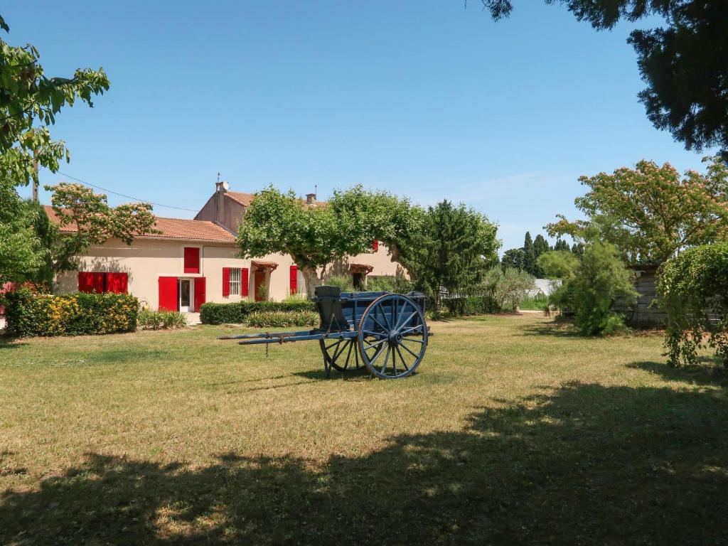 un chariot assis dans l'herbe devant une maison dans l'établissement Holiday Home Mas de la Gourmette by Interhome, à Châteaurenard