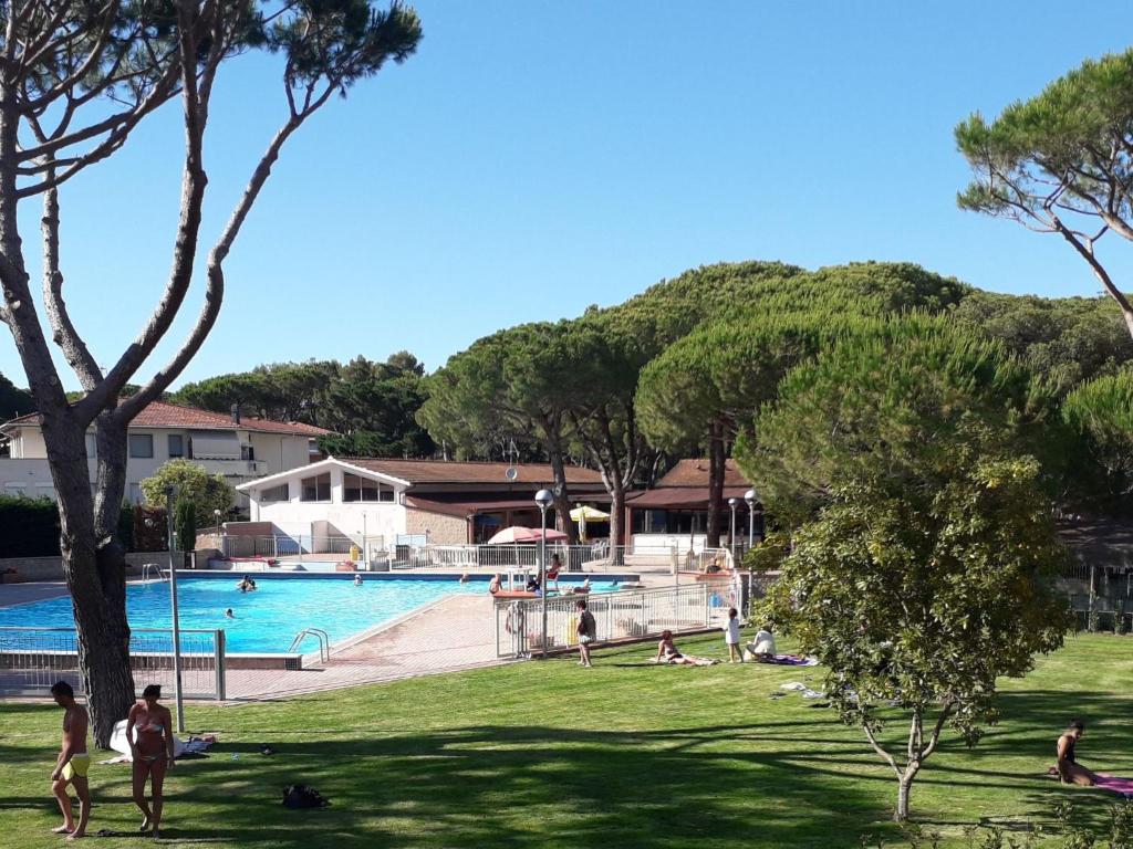 a group of people in a park near a swimming pool at Holiday Home Ponente Deluxe by Interhome in Marina di Bibbona