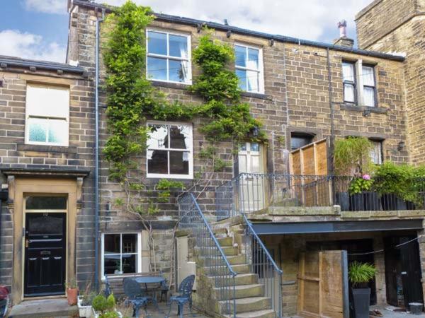 a brick building with a staircase in front of it at The Old Forge in Haworth