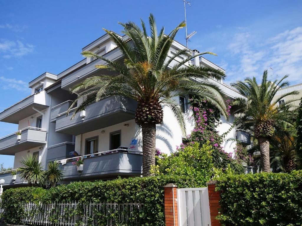 un edificio con palmeras delante en Apartment Cala Luna-1 by Interhome, en Porto dʼAscoli