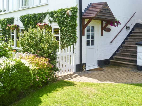 a white house with a white door and a fence at Severn Bank Lodge in Shrawley