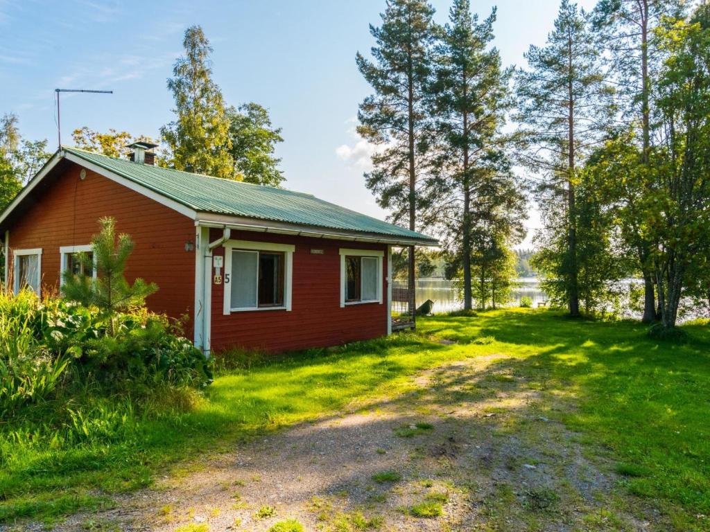 a small red house in the middle of a field at Holiday Home Saniainen 5 by Interhome in Säviä