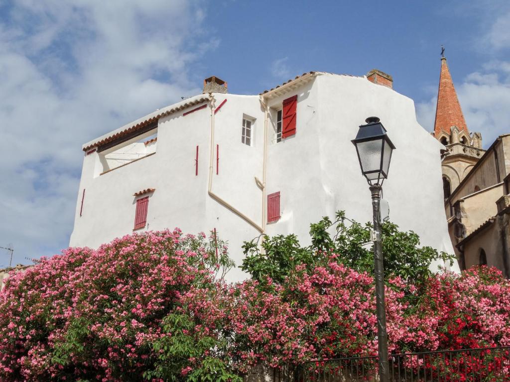 ラ・キャディエール・ダズールにあるHoliday Home La Cadièrienne by Interhomeの街灯前のピンクの花々が咲く建物