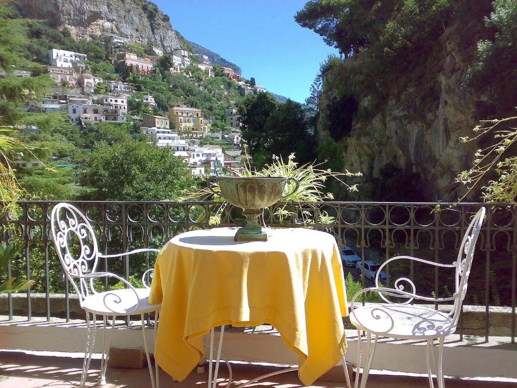 a table and chairs with a yellow table cloth on a balcony at Apartment Positano Elegant Terrace by Interhome in Positano