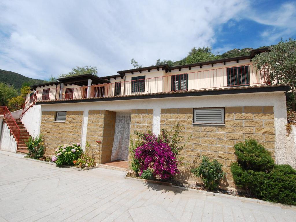 a large brick building with flowers in front of it at Apartment Is Murtas-4 by Interhome in Cardedu