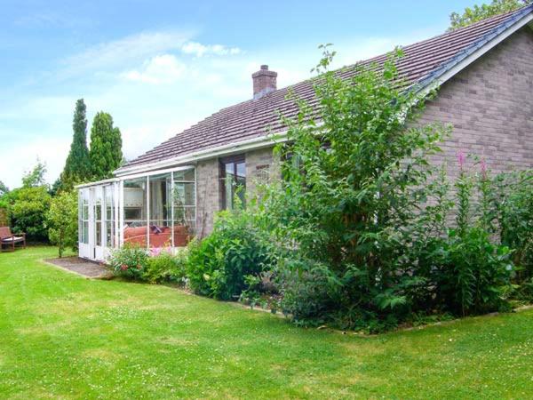 una casa de ladrillo con jardín en el patio en Bryn yr Haf, en Llanfair Clydogau