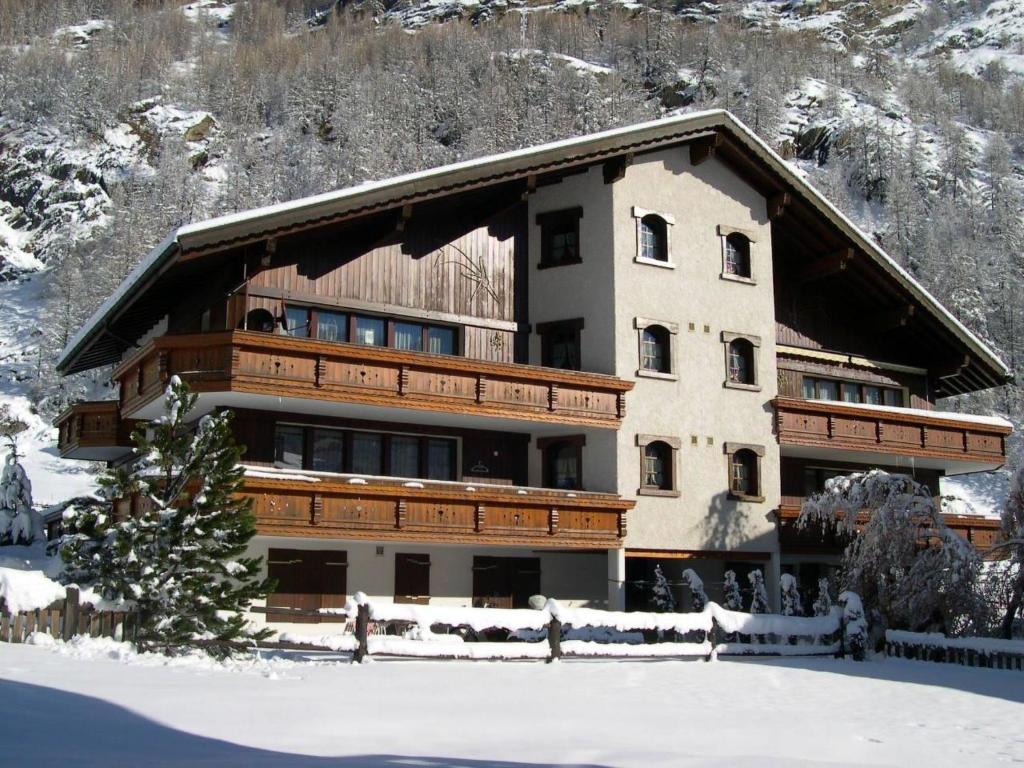 a large building with snow in front of it at Apartment Sunshine by Interhome in Saas-Grund