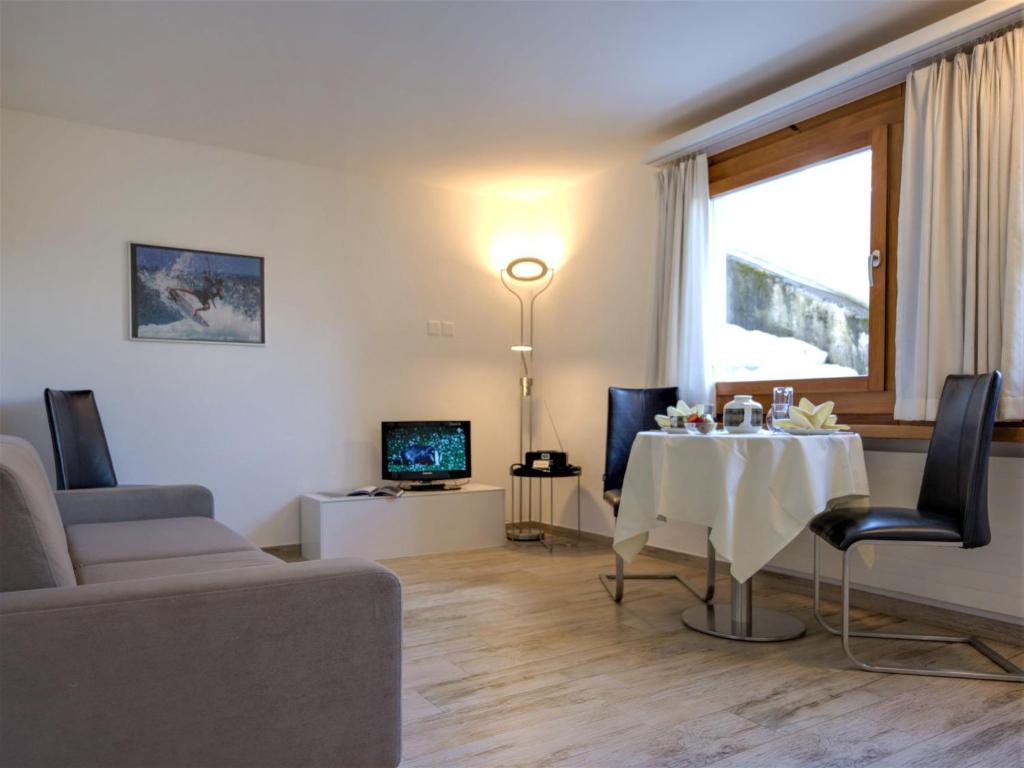 - un salon avec une table et un canapé dans l'établissement Apartment Chesa Munteratsch 311 by Interhome, à Silvaplana