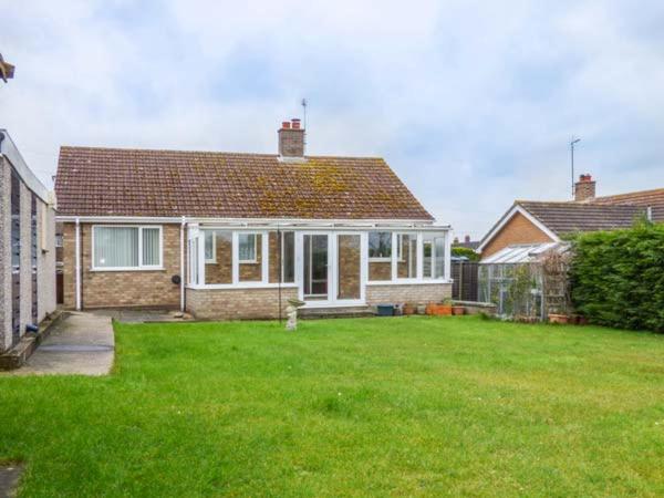 a house with a yard with a green lawn at Skylark in Holt