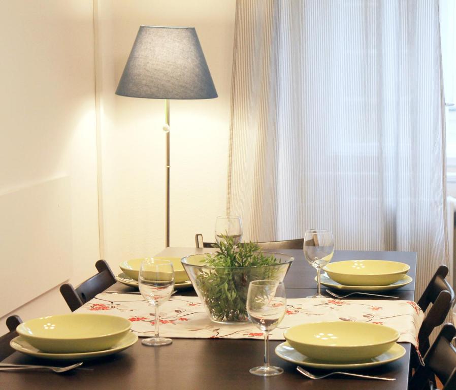 - une table à manger avec des assiettes et des verres à vin dans l'établissement Modern apartment Michalska 6, à Prague