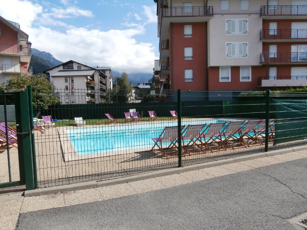 una piscina con tumbonas frente a un edificio en Apartment Le Grand Panorama-1 by Interhome, en Saint-Gervais-les-Bains