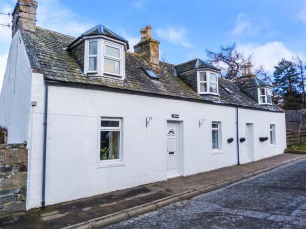 a white building with windows and a roof at Riemore in Tomintoul