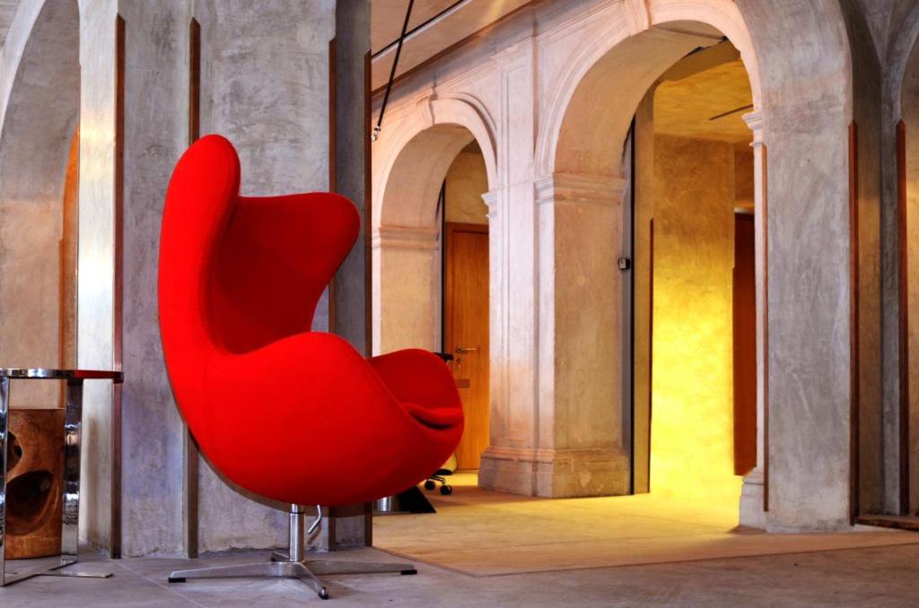 une chaise rouge assise à l'intérieur d'un bâtiment dans l'établissement Browns Downtown Hotel, à Lisbonne