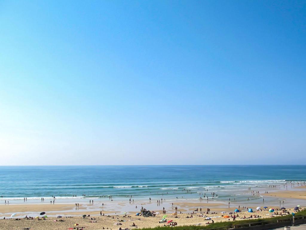 a group of people on a beach with the ocean at Apartment Grands espaces by Interhome in Mimizan-Plage