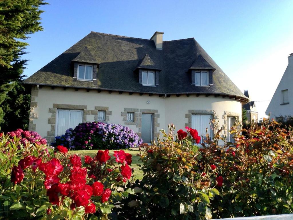 a house with a thatched roof and red flowers at Holiday Home Les Rimains by Interhome in Cancale