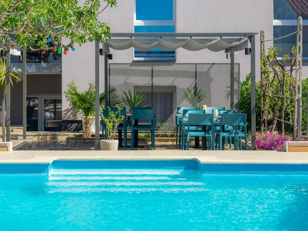 basen przed stołem i krzesłami w obiekcie Apartment Villa Jadranka-2 by Interhome w mieście Štinjan