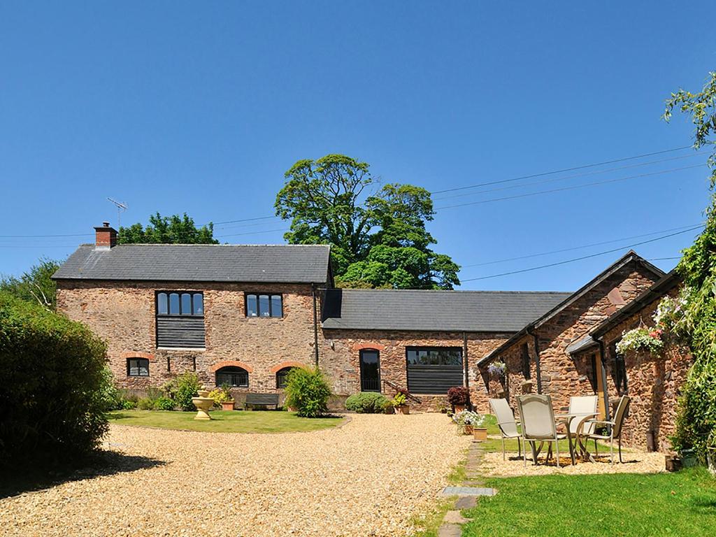 an old brick house with chairs in a yard at Rainsbury House in Taunton