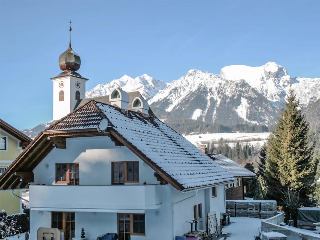 a church with a snow covered mountain in the background at Apartment Poldi by Interhome in Haus im Ennstal