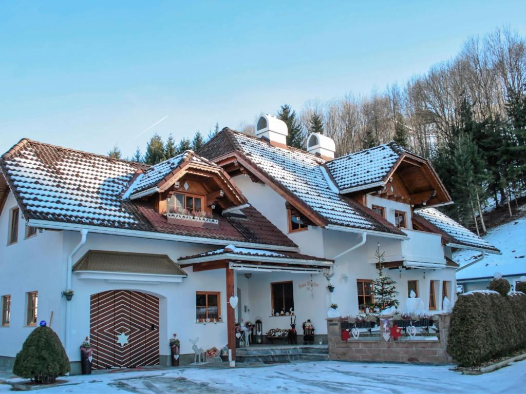 a house with tiled roofs in the snow at Apartment Poldi by Interhome in Haus im Ennstal