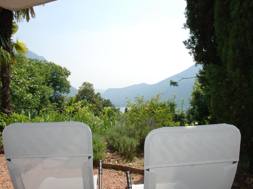 Deux chaises blanches dans un jardin avec des montagnes en arrière-plan dans l'établissement Studio Studio al vigneto by Interhome, à Rovio