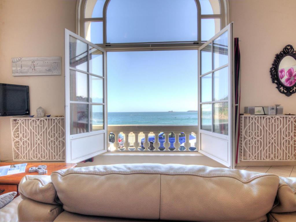 a living room with a couch and a view of the ocean at Apartment La Plage-1 by Interhome in Dinard