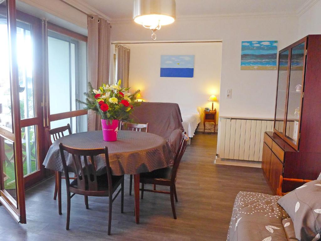 een kamer met een tafel met een vaas met bloemen erop bij Apartment Clos St Martin-5 by Interhome in Biarritz