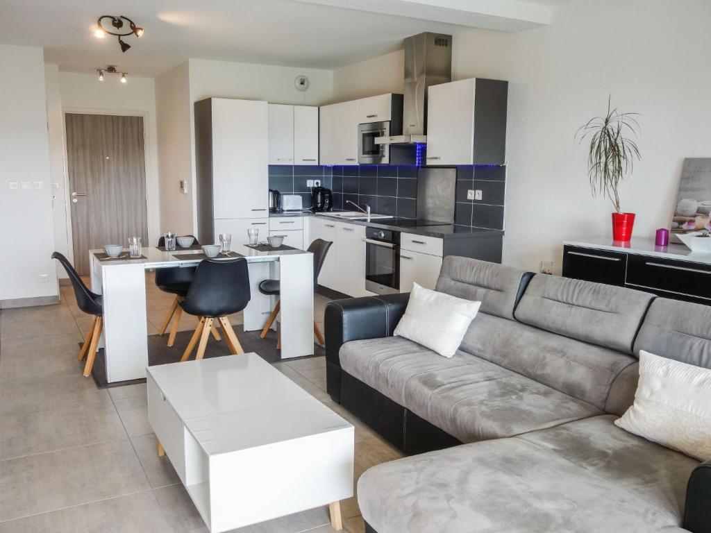 Il comprend un salon avec un canapé et une cuisine. dans l'établissement Apartment Terrasse de Lucie by Interhome, à Saint-Cyprien