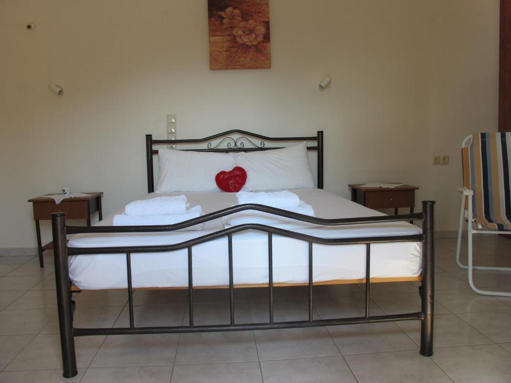 a bed with a red heart sitting on top of it at Porto Kastri Studios in Kastrí