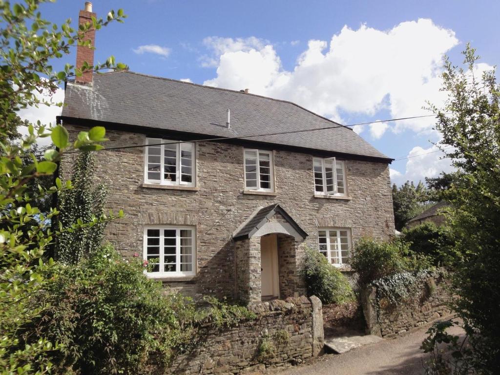 Casa de piedra antigua con ventanas blancas en Maristow Barton, en Plymouth