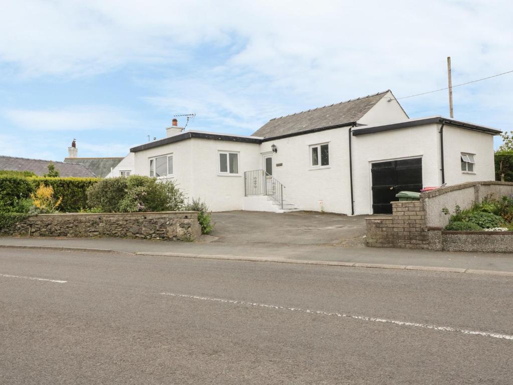 a white house on the side of a street at Bedlinog in Amlwch