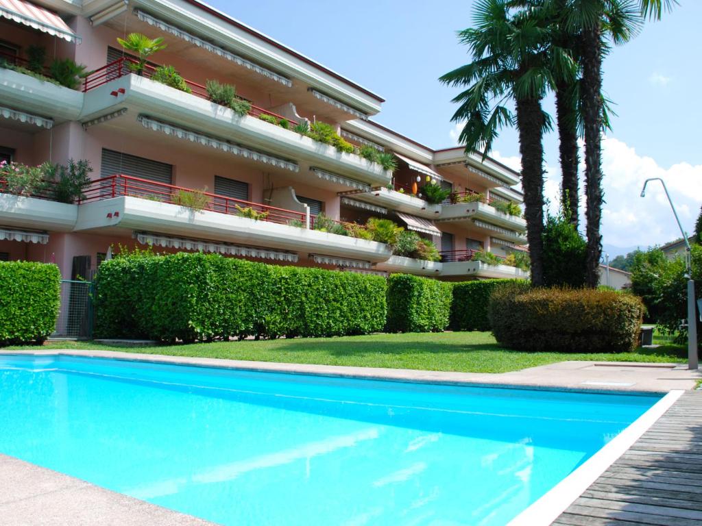 a building with a swimming pool in front of a building at Apartment Caslago-2 by Interhome in Caslano