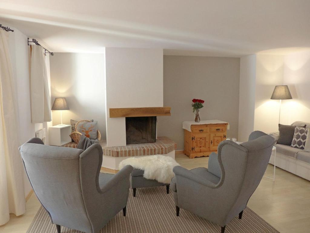 uma sala de estar com duas cadeiras e uma lareira em Apartment Chesa Fuolla Verda A8 by Interhome em Celerina