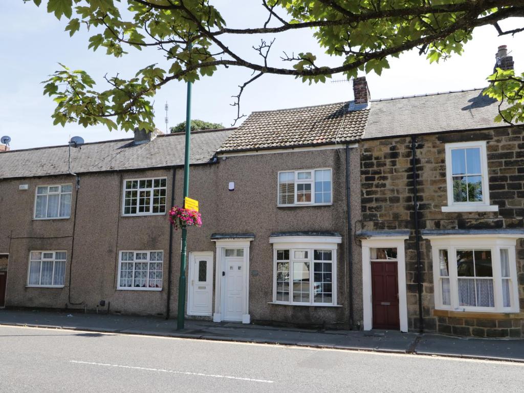 a brick building with a flag on a street at White Rose Cottage in Guisborough